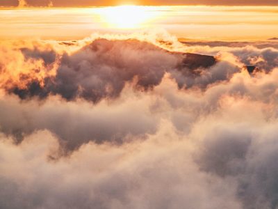 mountain covered in clouds during golden hour