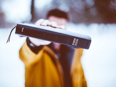 person holding Holy Bible