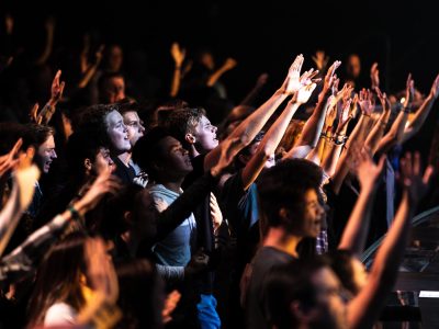 people raising their hands during night time