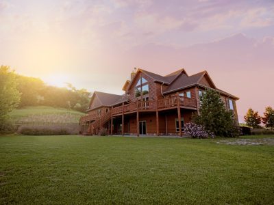 brown wooden house with green grass field