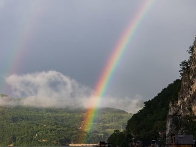 a double rainbow is seen over a body of water